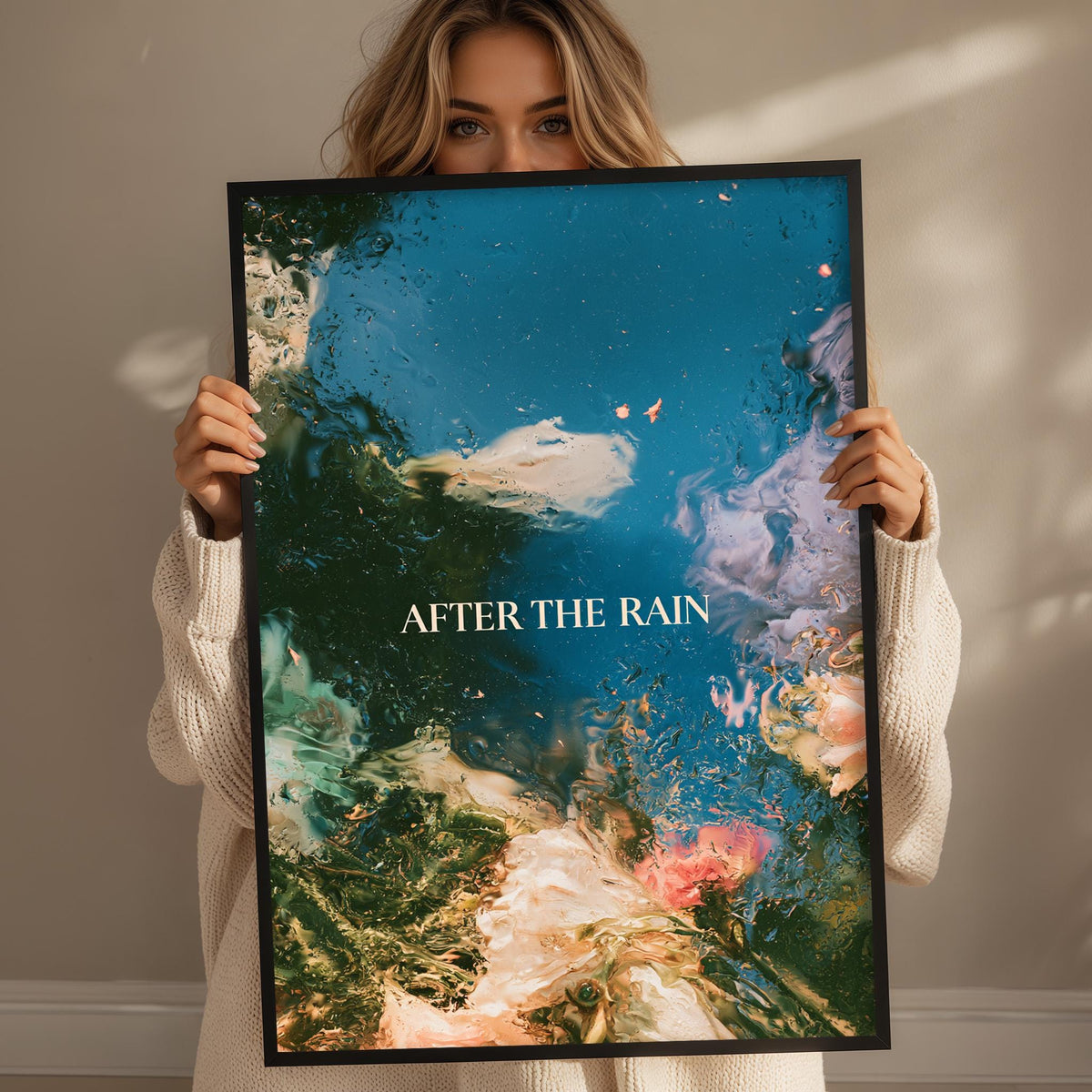 A woman holding a framed poster with a colorful abstract design, including elements like water, flowers, and clouds.