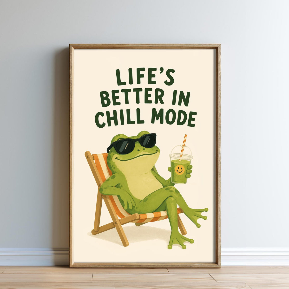 A framed illustration of a green frog sitting in a chair, wearing sunglasses and holding a drink, with the text "LIFE'S BETTER IN CHILL MODE" above the image.