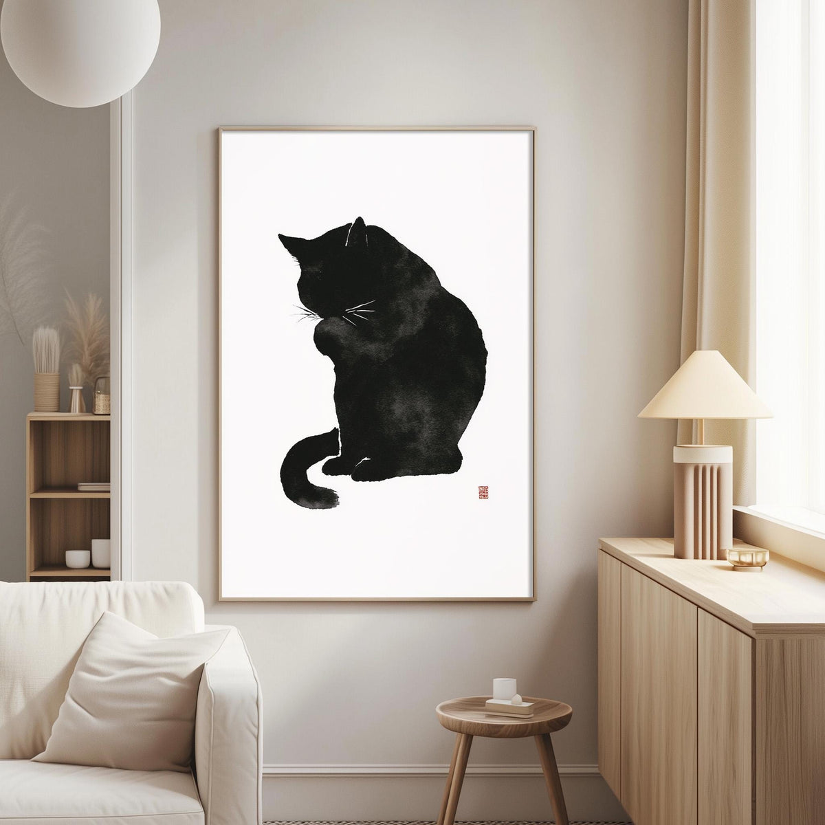 a black cat sitting on a white wall, with a framed print of the cat as the focal point.