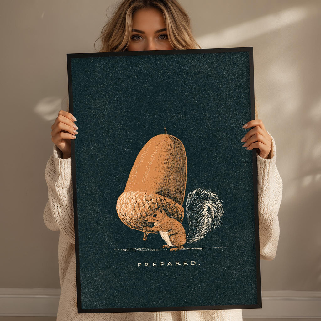 A woman holding a framed print with an illustration of a squirrel and an acorn.