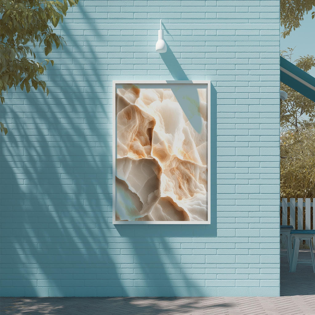 a blue brick wall with a framed abstract painting hanging on it. The painting has a textured, organic appearance with a mix of light and dark colors. The wall is situated next to a wooden deck and a tree, creating a serene and natural setting.