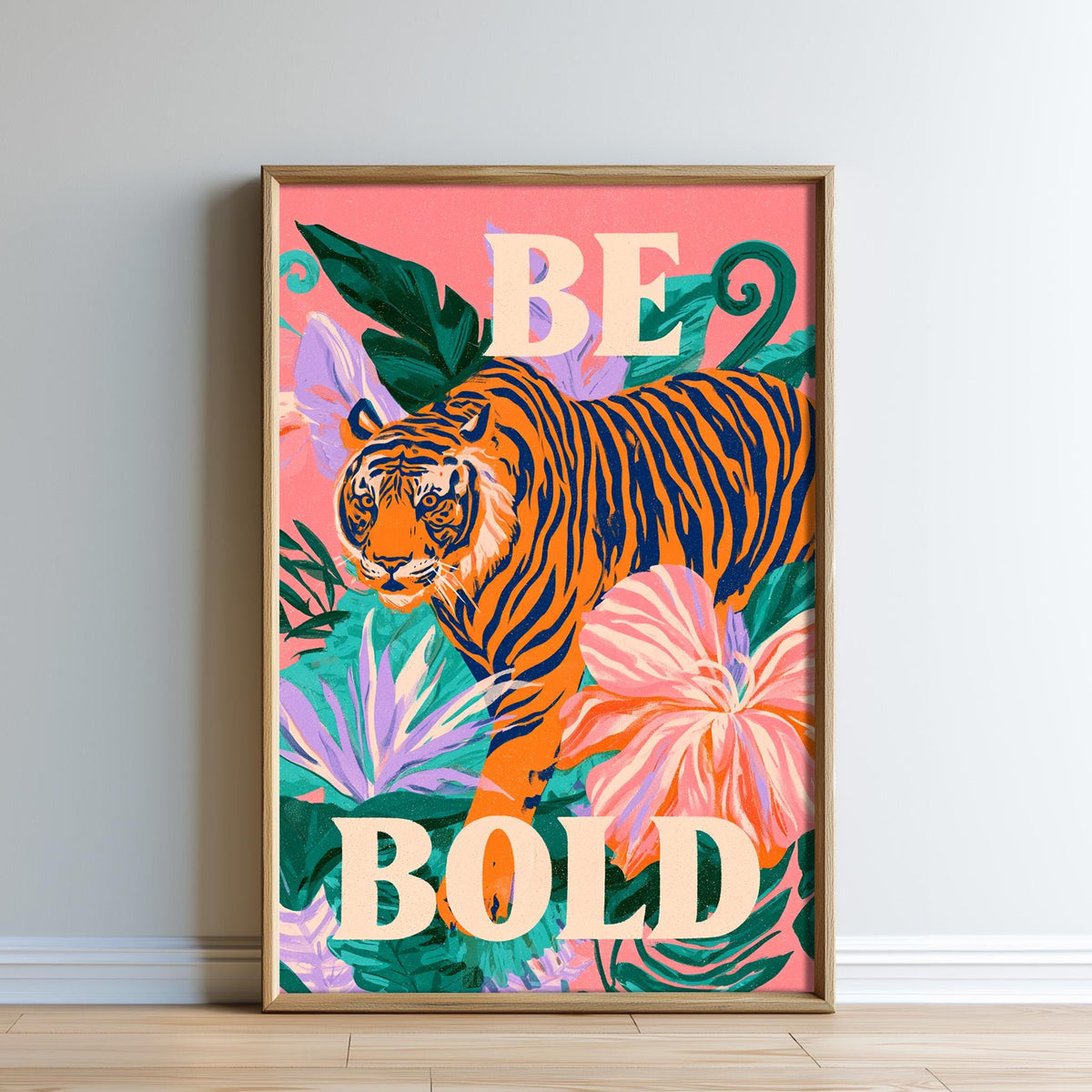 A framed poster with a vibrant illustration of a tiger surrounded by tropical foliage and flowers, with the text "BE BOLD" prominently displayed.
