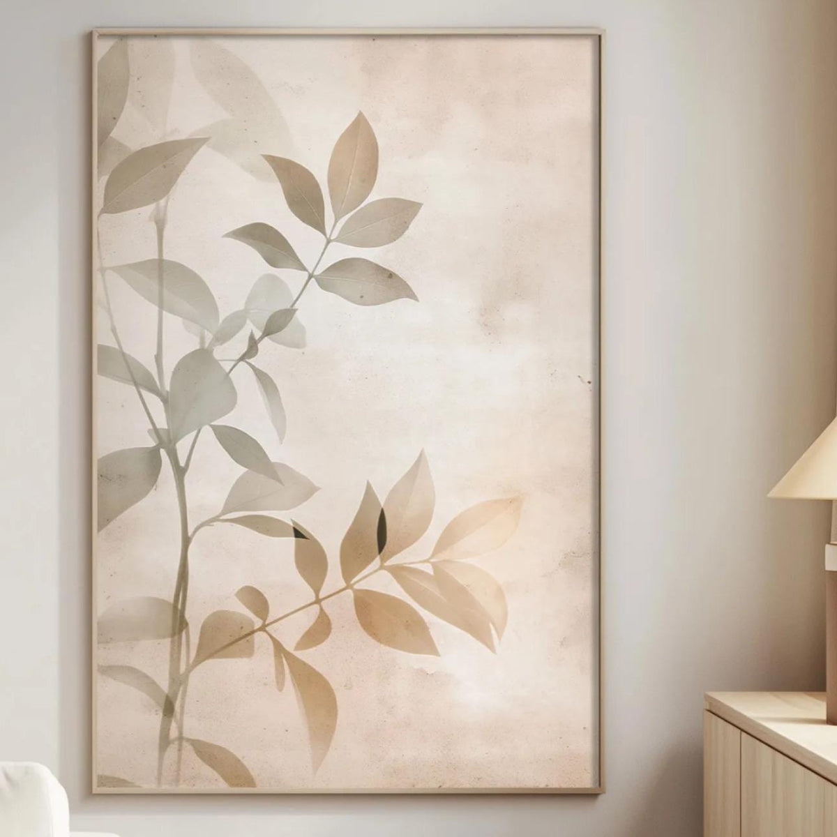 a serene and modern living room with a large framed print of a leafy plant on the wall, a white sofa, a wooden side table, and a lamp on a wooden cabinet.