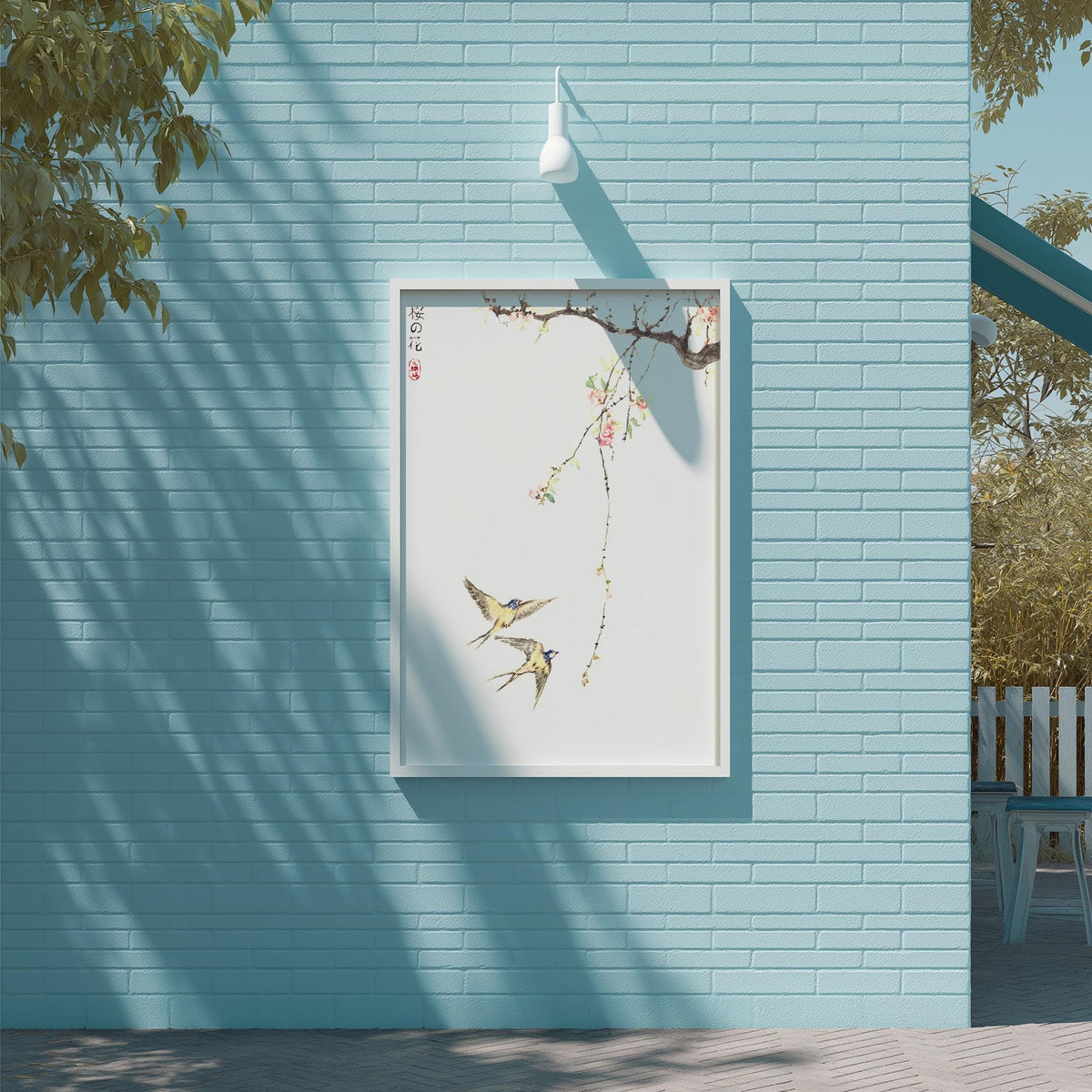 a blue brick wall with a framed painting of two birds on a branch hanging on it. The painting is set against a light blue background, creating a serene and calming atmosphere.