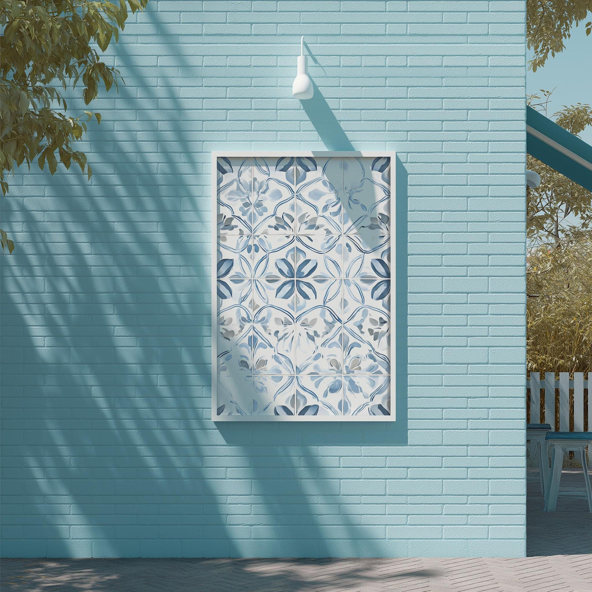 a blue brick wall with a white frame containing a pattern of blue and white tiles. The wall is situated next to a tree and a white light fixture is mounted on the wall.
