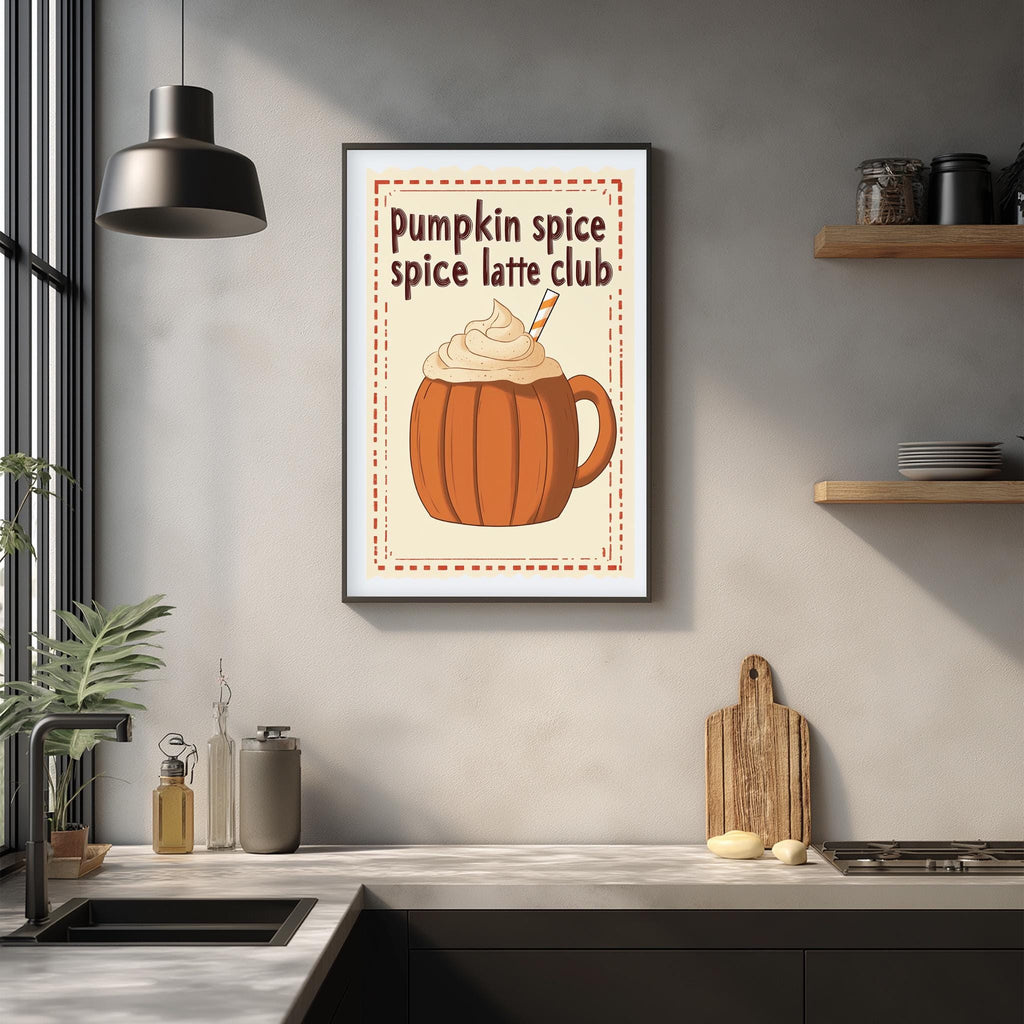A framed poster with an illustration of a pumpkin spice latte is displayed on a wall above a kitchen counter with various kitchen items and a plant.