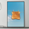 a cozy living room with a gray sofa, a coffee table, and a large framed picture of a piece of bread hanging from a clothesline.