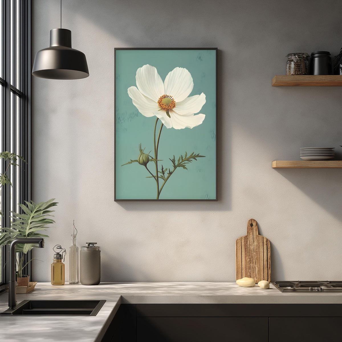 a kitchen counter with a framed white flower painting hanging above it, a wooden cutting board, and various kitchen items such as a bottle, a can, and a bowl.
