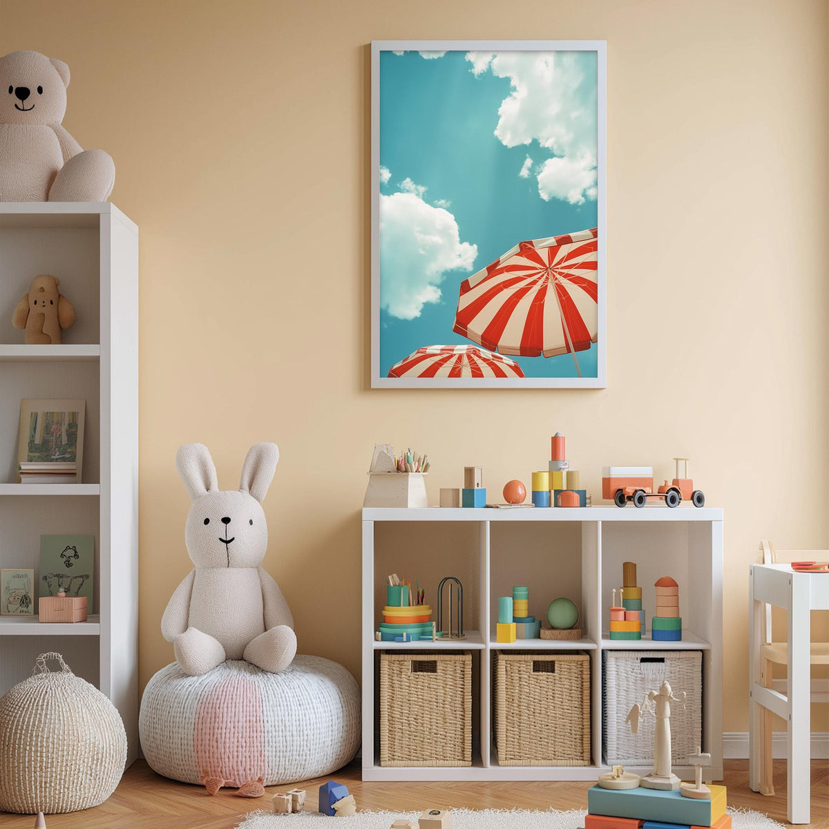 A cozy children's room with a white rabbit sitting on a bean bag chair, surrounded by toys and storage bins. A framed picture of a beach scene with striped umbrellas is displayed on the wall above a bookshelf filled with books and toys.