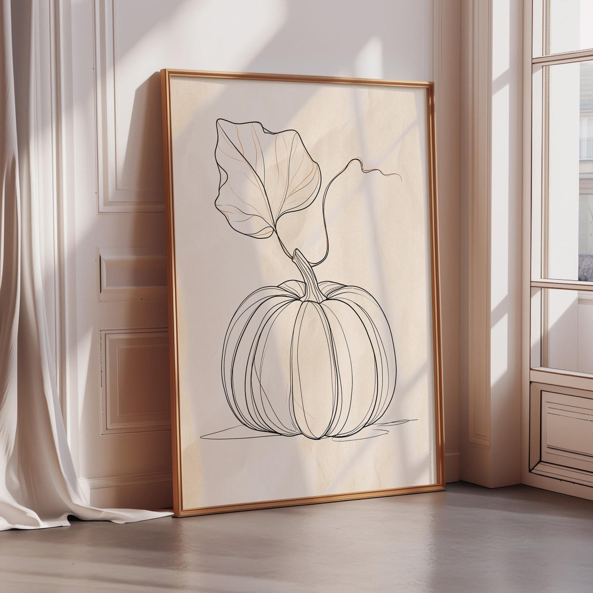 A framed print of a pumpkin with a leaf is displayed on a wall in a room with a window.