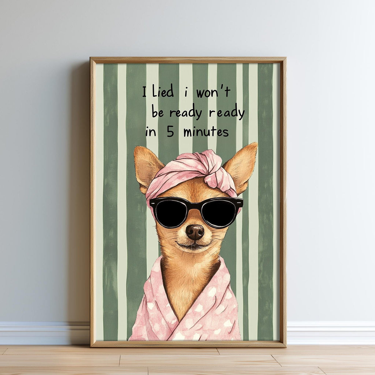 A framed illustration of a dog wearing sunglasses, a pink headband, and a pink towel, with the text "I lie I won't be ready ready in 5 minutes" above the dog.