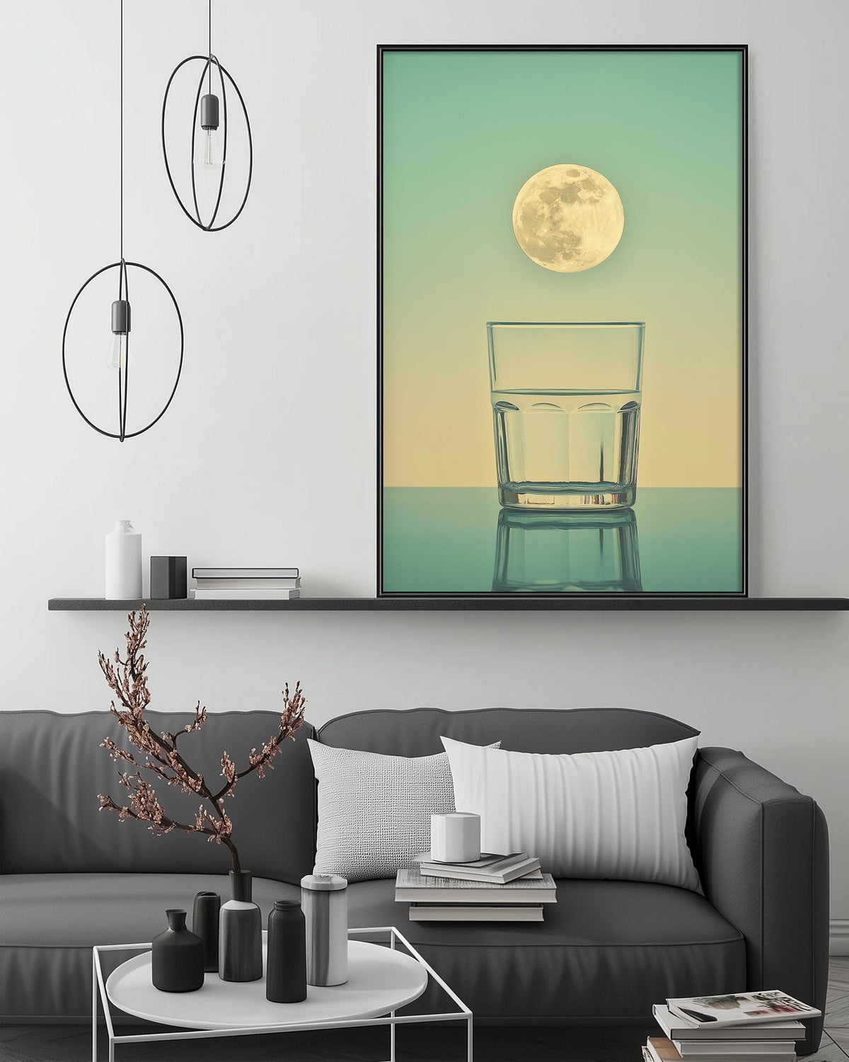 a modern living room with a gray sofa, a coffee table, and a large framed picture of a glass of water with a full moon in the background.