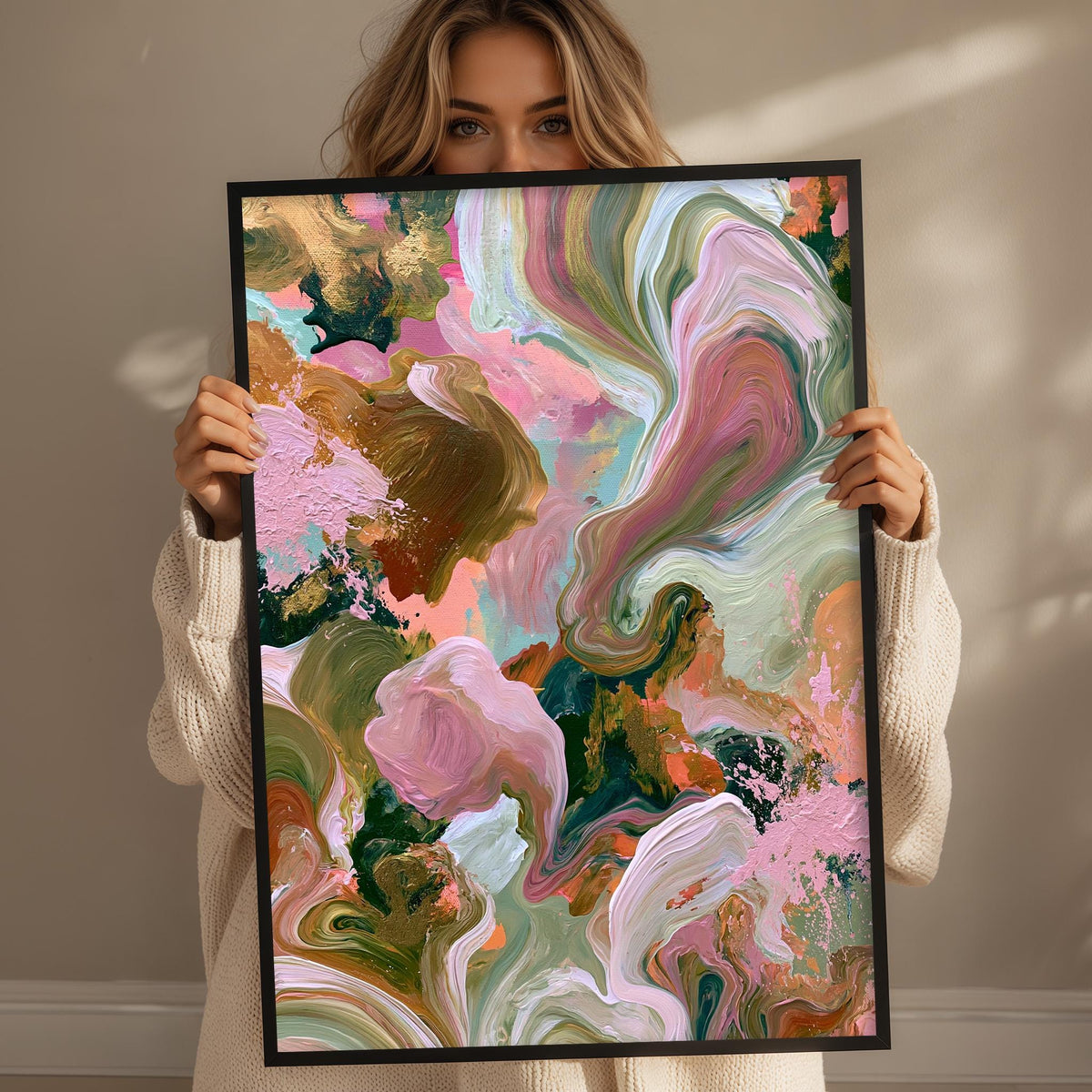 A woman holds up a framed abstract painting with vibrant colors and swirling patterns.