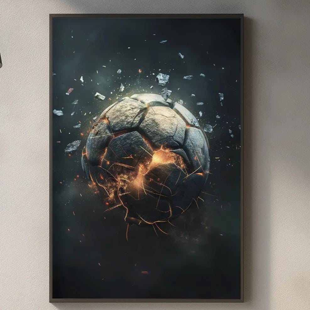 a kitchen counter with various kitchen items, including a cutting board, a bottle, and a vase. Above the counter, there is a framed artwork depicting a soccer ball with flames or sparks emanating from it, creating a dramatic and fiery effect.