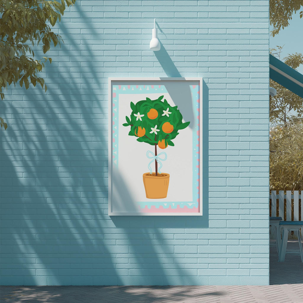 A framed illustration of a potted tree with orange flowers is displayed on a blue brick wall.