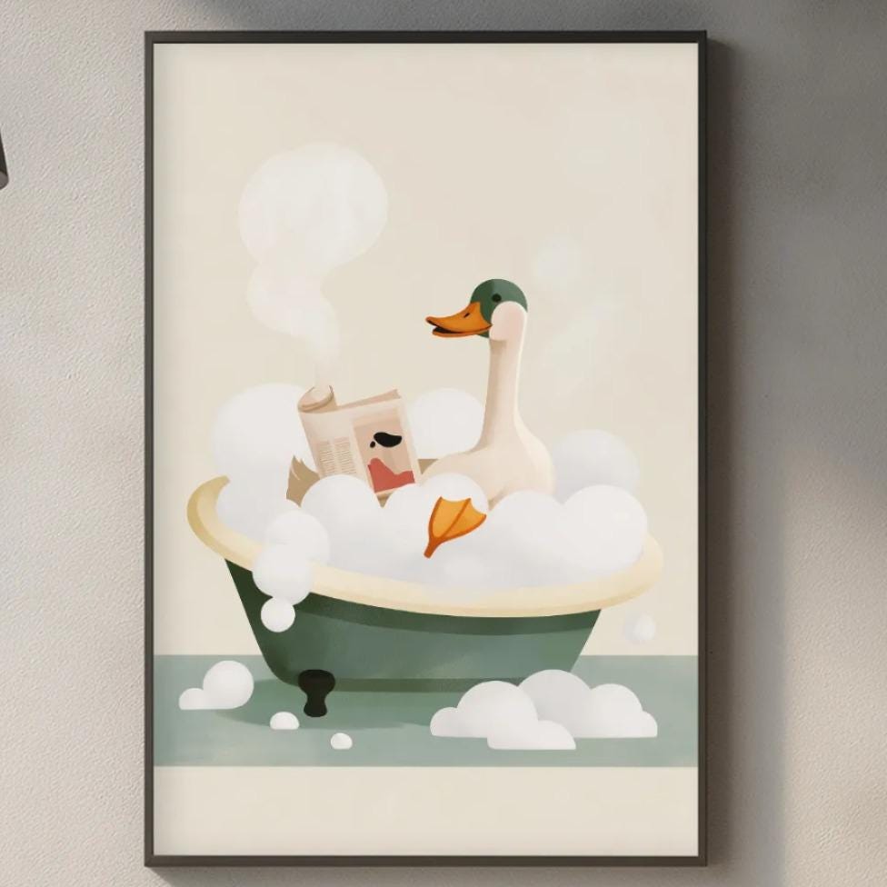 a framed illustration of a duck sitting in a bathtub filled with bubbles, hanging on a wall above a kitchen counter.