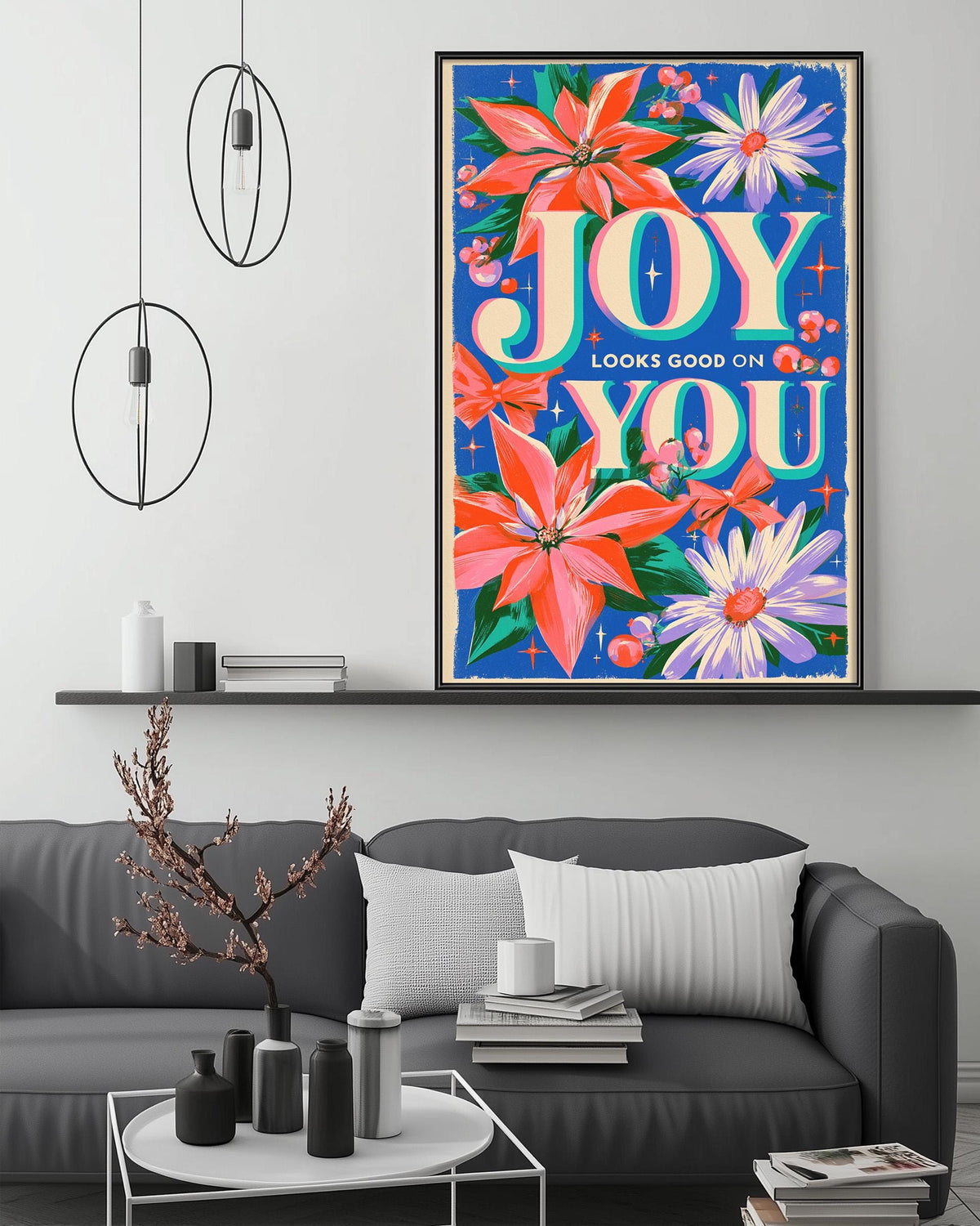 a large, colorful poster of flowers hanging on a wall above a gray couch in a living room setting.