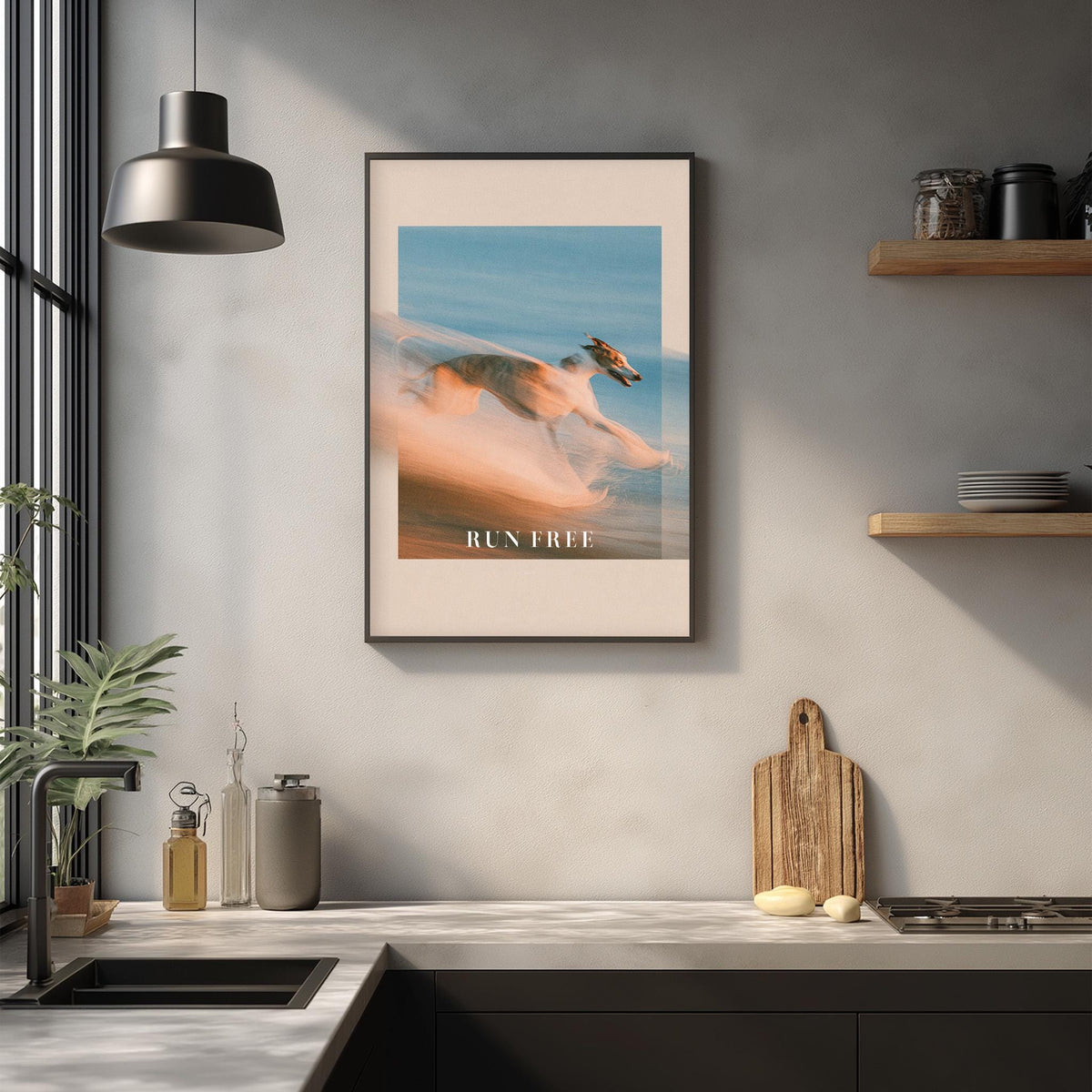 a framed poster of a dog running in the air, hanging on a wall above a kitchen counter with various kitchen items and decor.