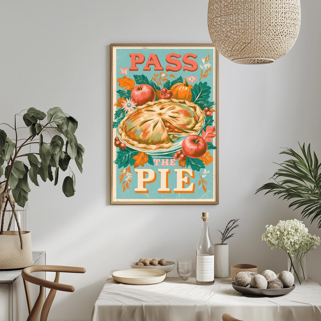 a framed poster with the text "Pass the Pie" hanging on a wall above a dining table with various items on it.
