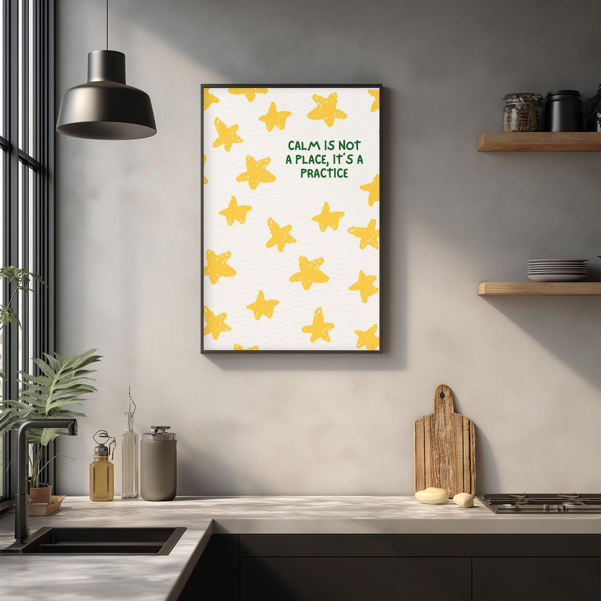 a kitchen counter with a framed poster of yellow stars hanging on the wall above it. The poster has the text "Calm is not a place, it's a practice" written on it.