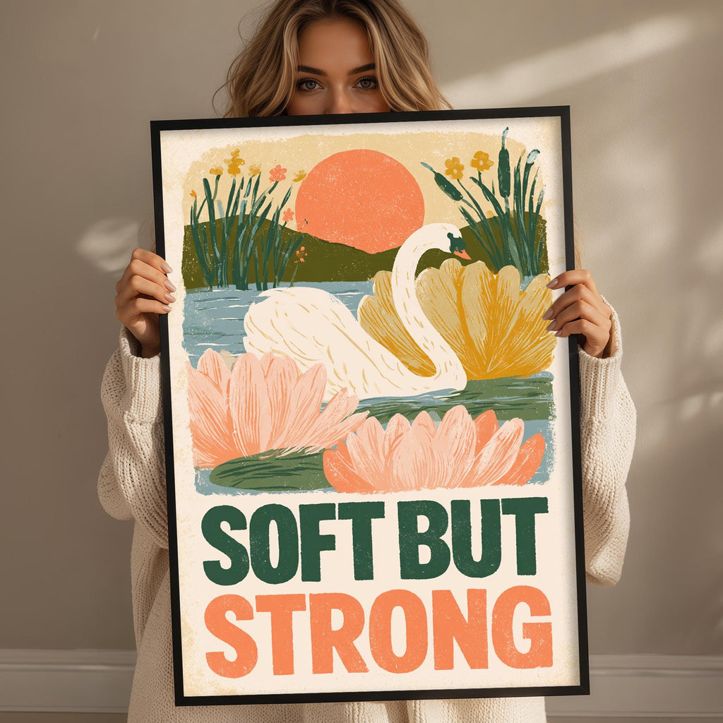 A woman holding a framed poster with a colorful illustration of a swan and flowers.