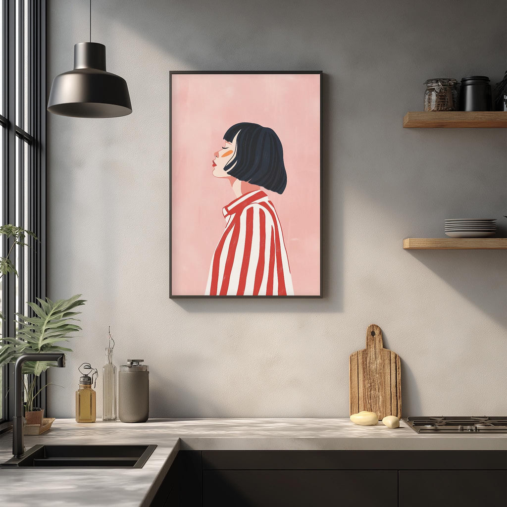 a kitchen counter with a framed illustration of a woman wearing a red and white striped shirt, hanging on the wall above it.