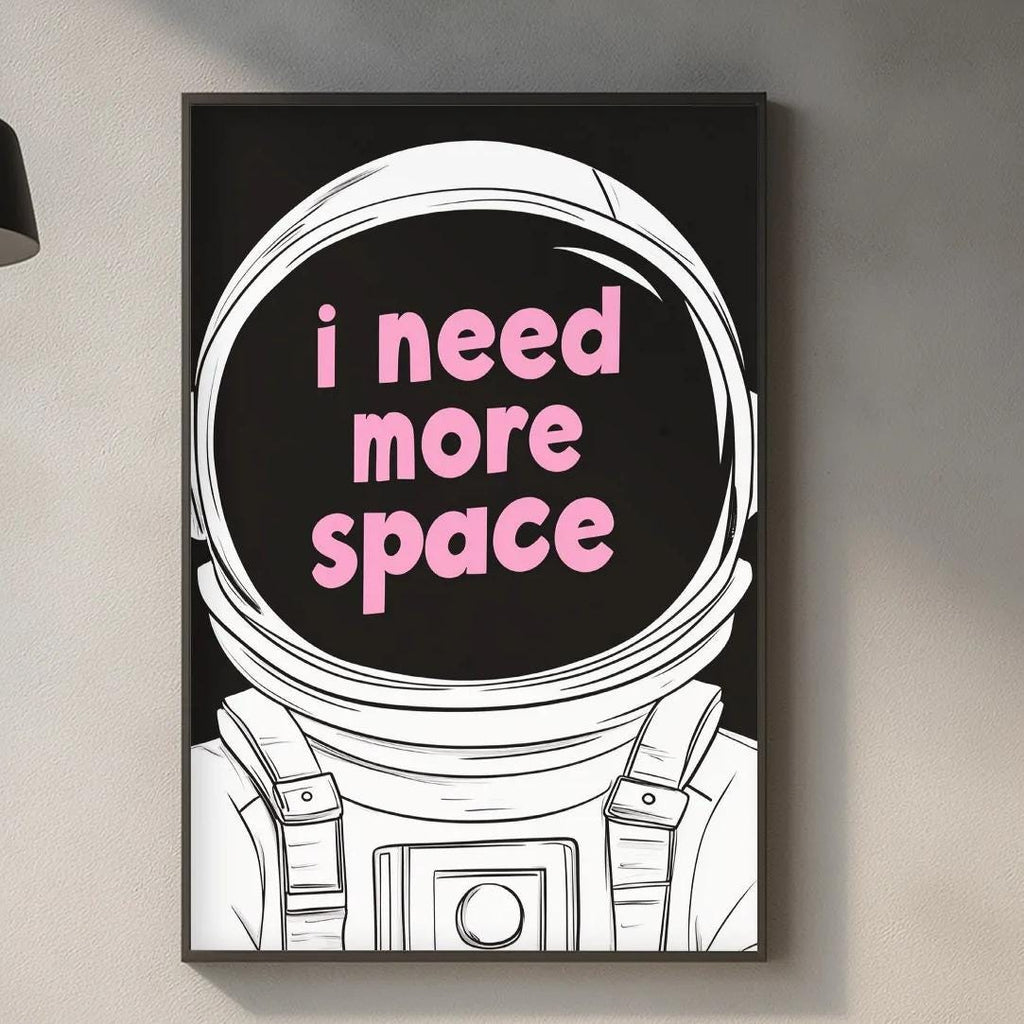 a kitchen counter with various kitchen items, such as a cutting board, a bottle, and a bowl. Above the counter, there is a framed poster with the text "I need more space" in pink letters.
