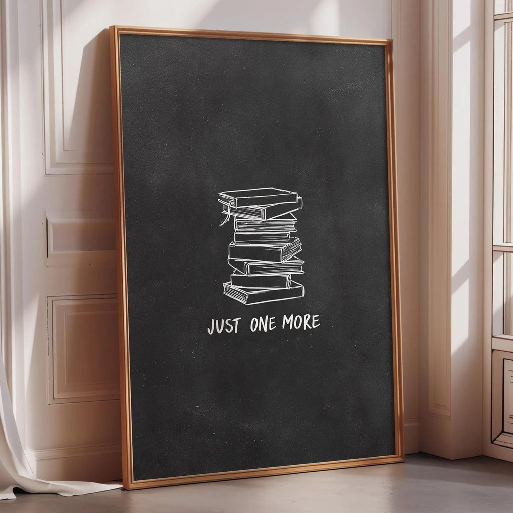 A large blackboard with a stack of books on it, and the text "JUST ONE MORE" written on it.