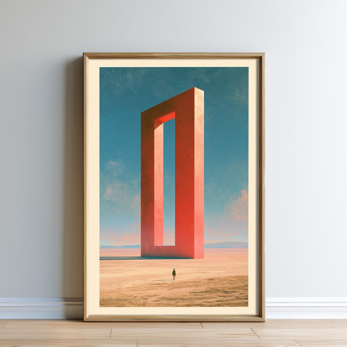 The image is a framed artwork depicting a person standing in a desert landscape with a large, red, rectangular structure in the background.