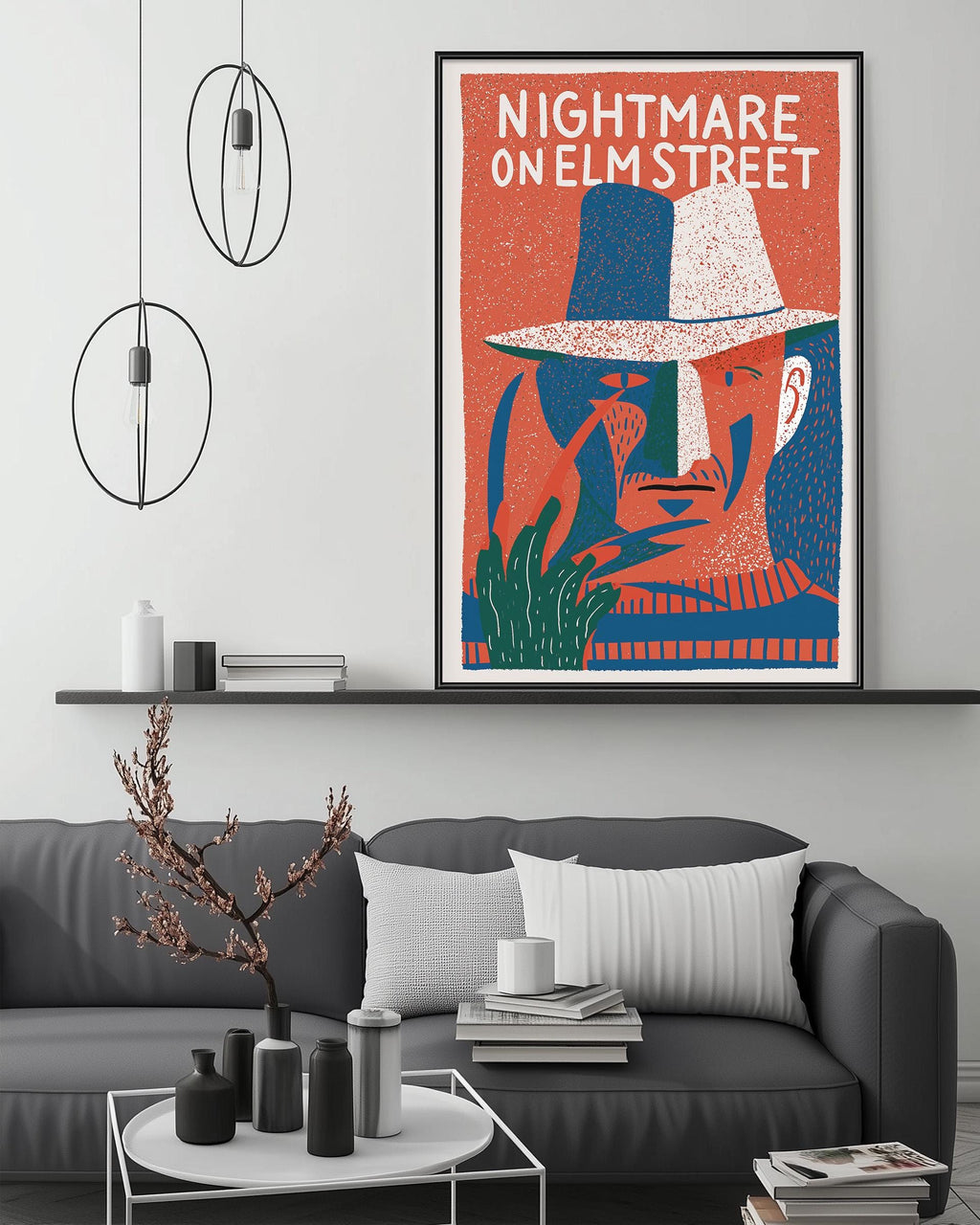 a poster of a man's face with a hat, hanging on a wall above a gray couch with a coffee table in front of it.