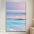 a large framed poster of a seascape with the text "LET IT BE" displayed prominently on it. The poster is hanging on a wall in a living room setting, with a white couch and a small table nearby.