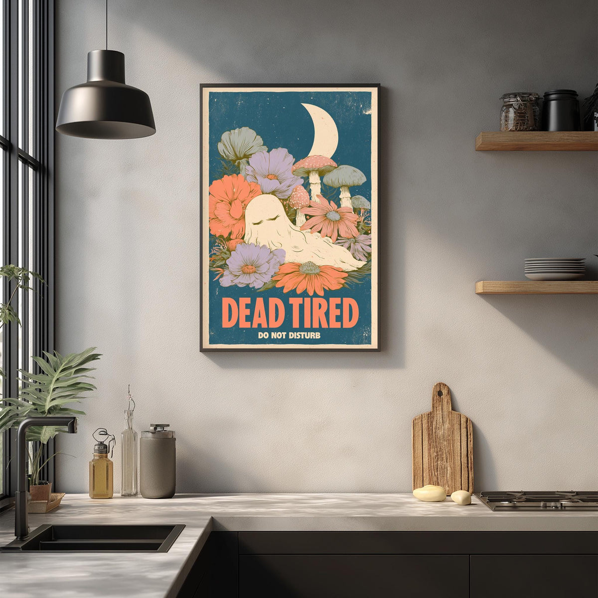 a framed poster with a whimsical illustration of a sleeping ghost surrounded by flowers and mushrooms, hanging on a wall above a kitchen counter.