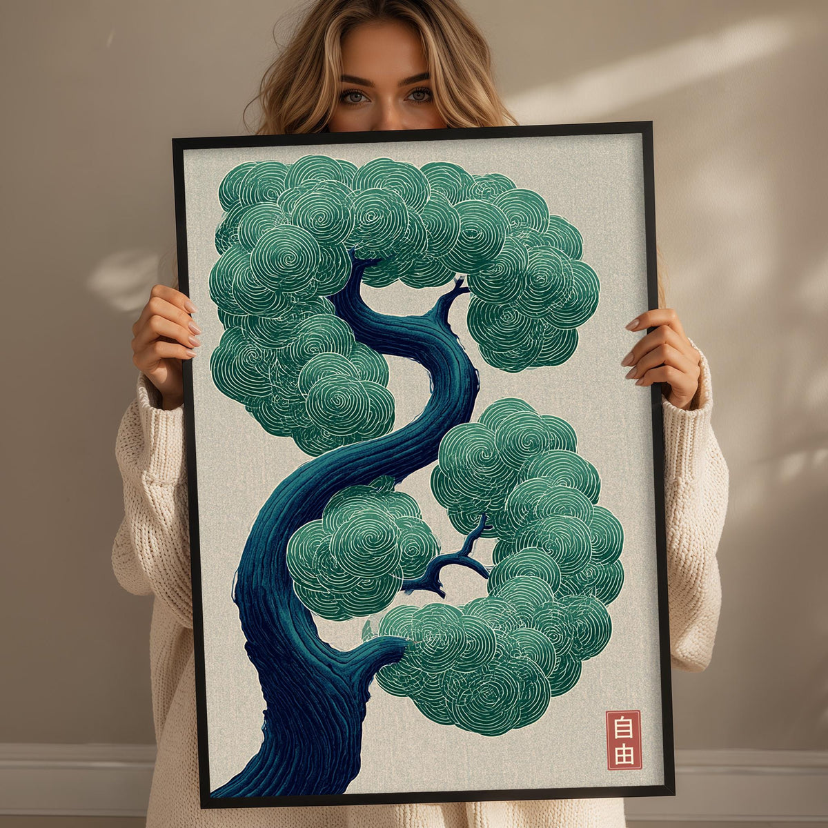 A woman is holding up a framed artwork depicting a stylized tree with intricate, swirling patterns in shades of blue and green.