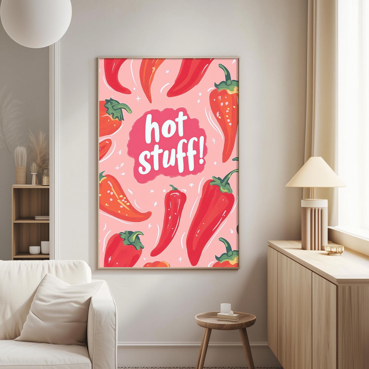a vibrant poster with a playful design of red peppers and the text "hot stuff!" displayed on a wall in a cozy living room setting.