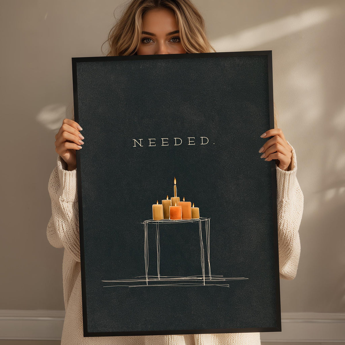 A woman holding a black poster with a drawing of candles on a table.