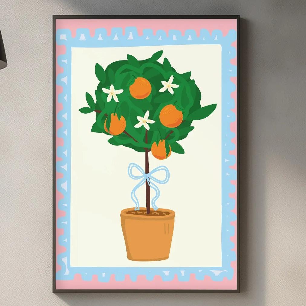 a kitchen counter with a potted plant, a cutting board, and various kitchen items such as a bottle and a vase. Above the counter, there is a framed illustration of a tree with orange flowers and green leaves.