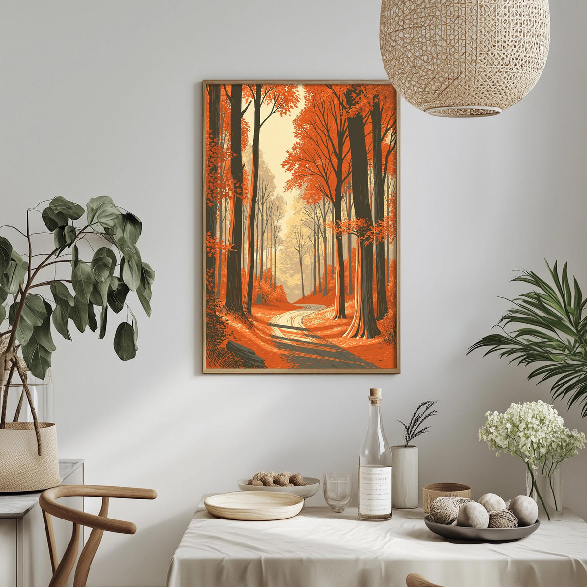 a dining table with a white tablecloth, a bottle, a bowl, and a vase with flowers. Above the table, there is a framed painting depicting a forest scene with a winding path.