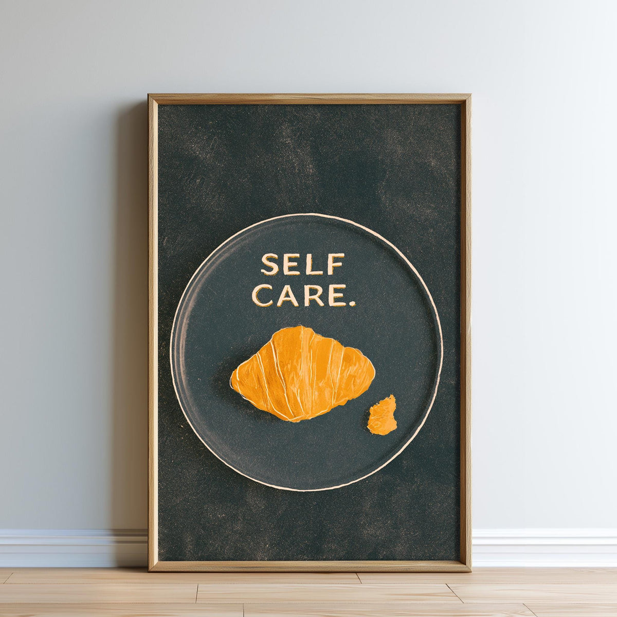 a framed poster with the text "SELF CARE" and an illustration of a croissant.