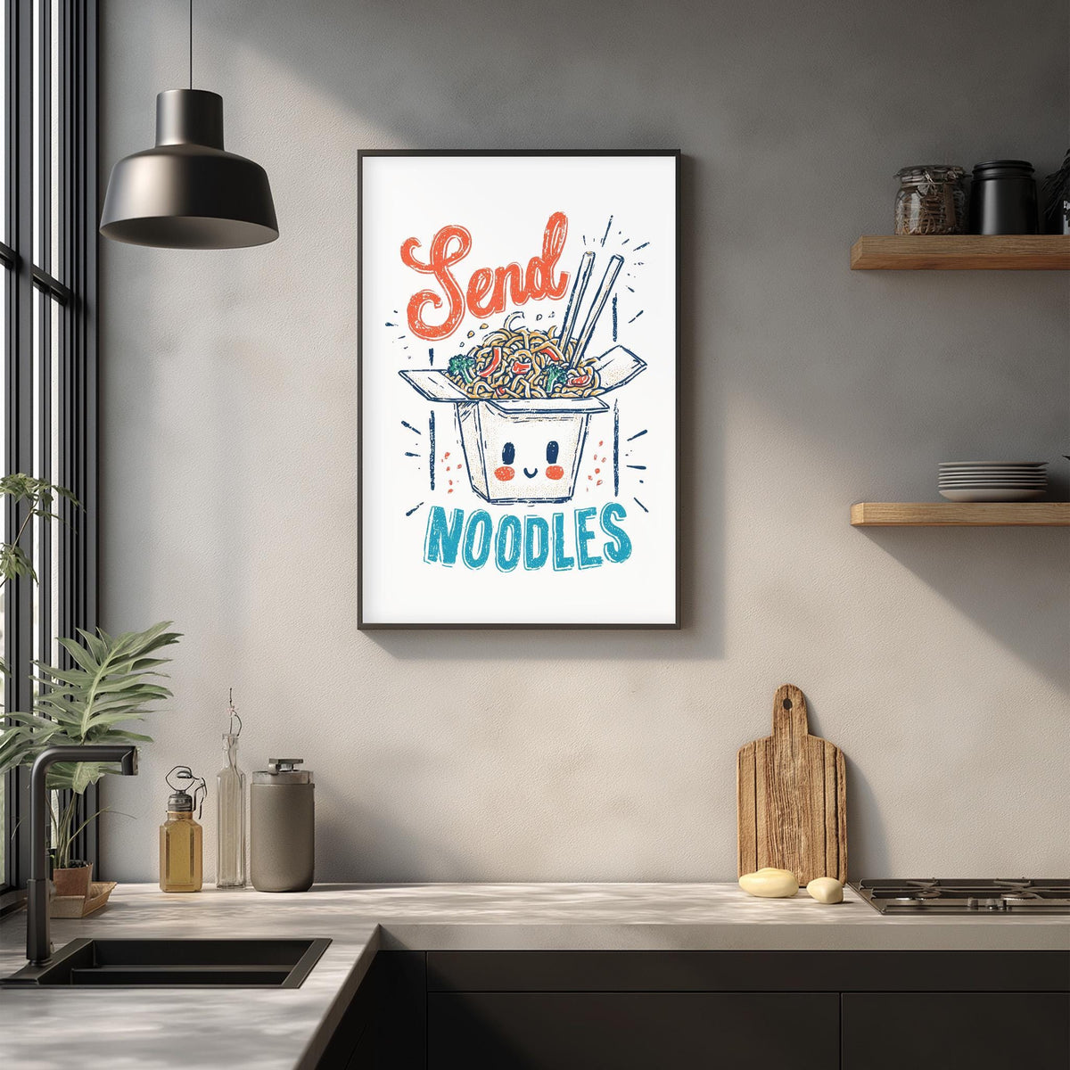 a kitchen counter with various items, including a framed poster with a cartoon noodle box and the text "Send Noodles" above it.