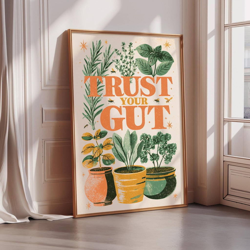 a framed poster with a vibrant illustration of potted plants and the text "Trust Your Gut" displayed on it.