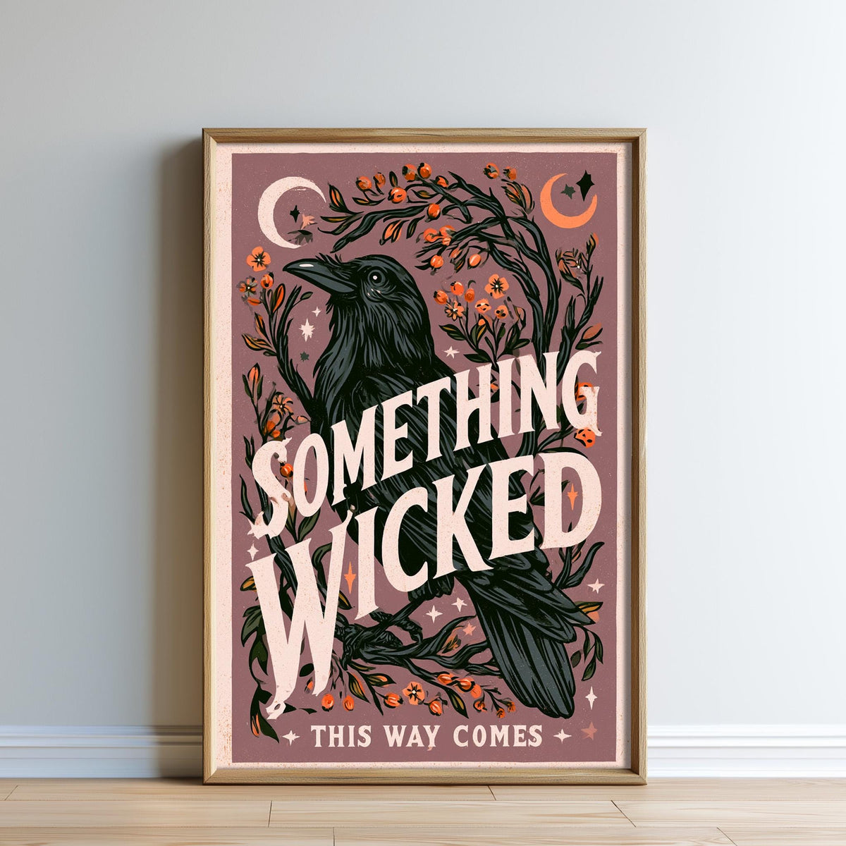 The image is a framed poster with a black crow and various floral and celestial elements, including a crescent moon and stars. The text on the poster reads "Something Wicked This Way Comes", and the phrase "THIS WAY COMES" is also present.