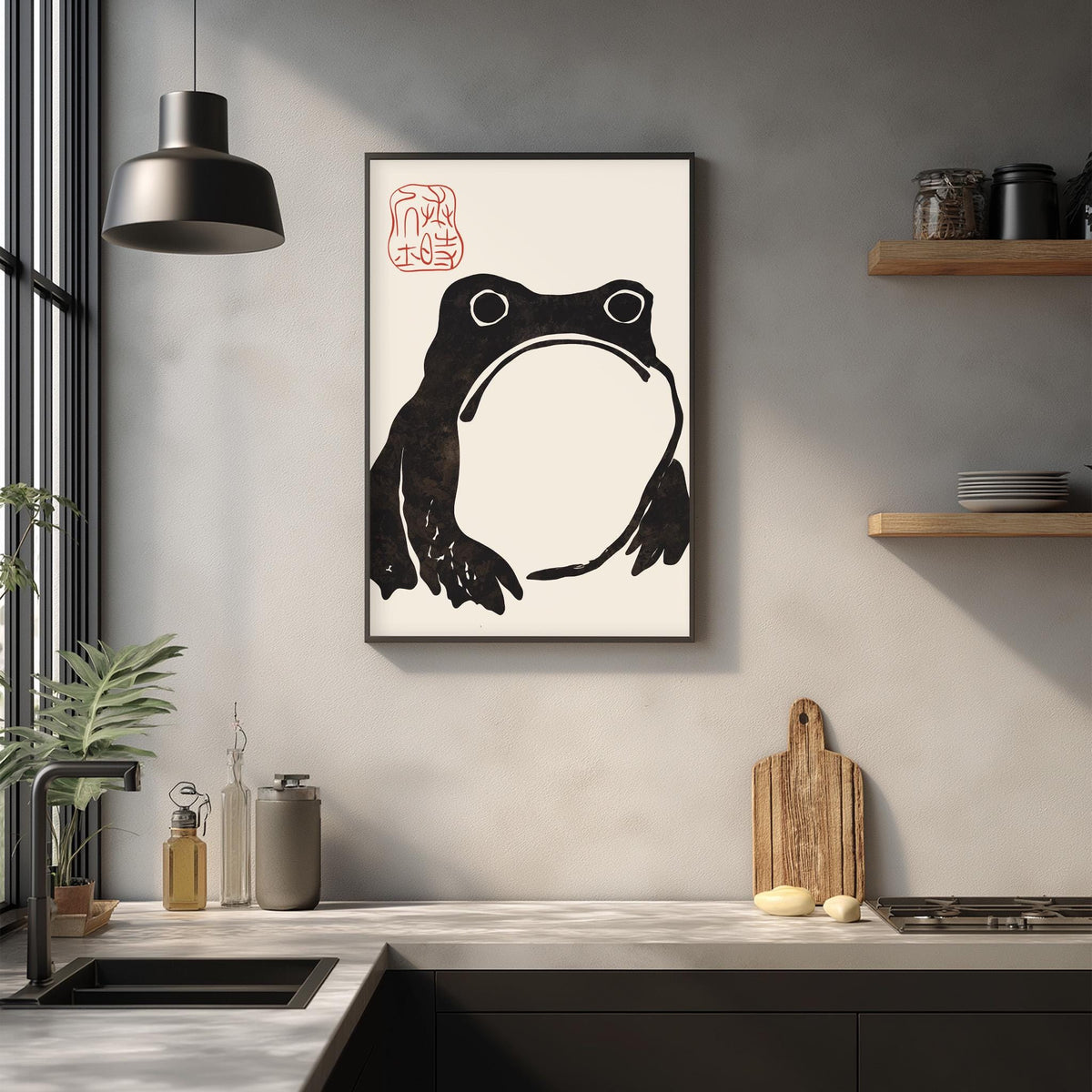a kitchen counter with a framed picture of a frog, a wooden cutting board, and various kitchen items such as a bottle, a can, and a bowl.