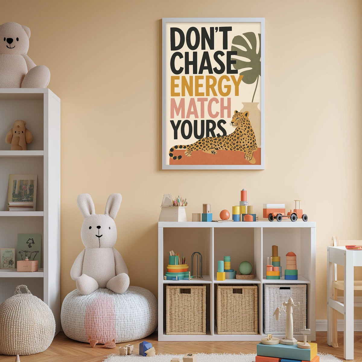 A child's bedroom with a white bookshelf, a stuffed rabbit, and a colorful poster on the wall. The poster has the text "DON'T CHASE ENERGY MATCH YURS" and features an illustration of a leopard.