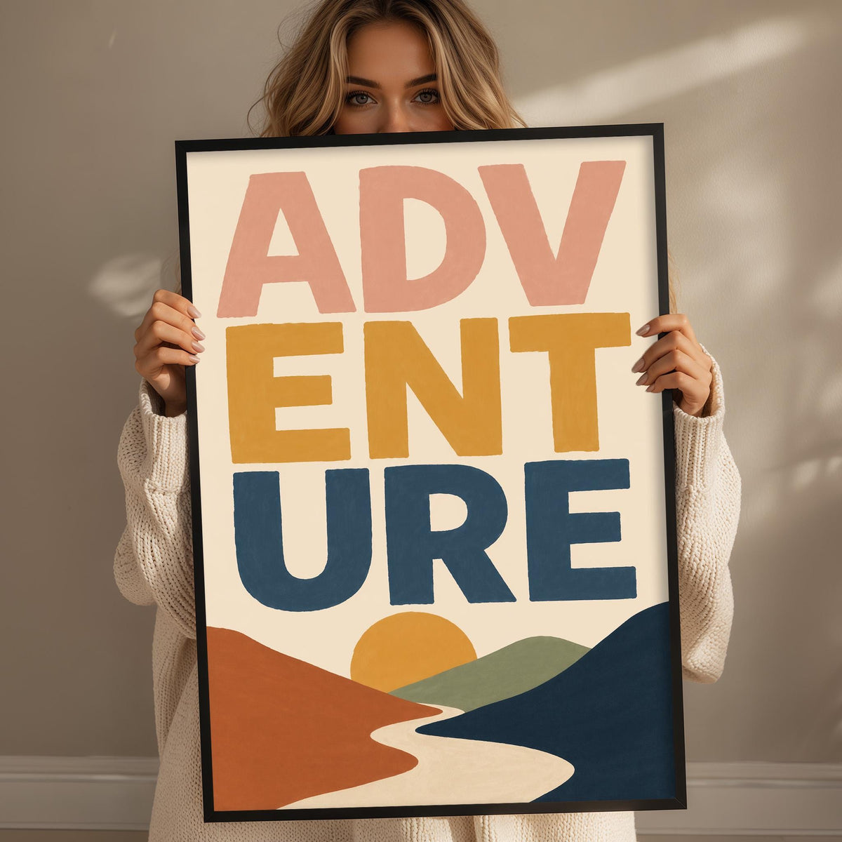 A woman holding a framed poster with the text "ADVENTURE" on it.