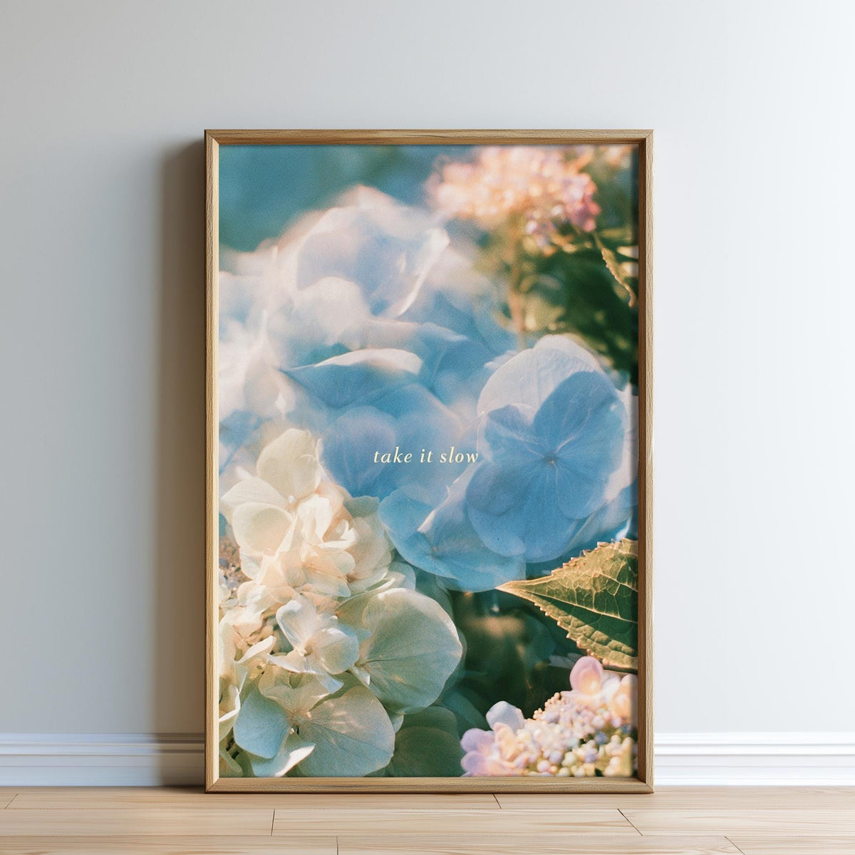 The image is a framed print of a close-up of a flower, with the text "Take it slow" written on it.