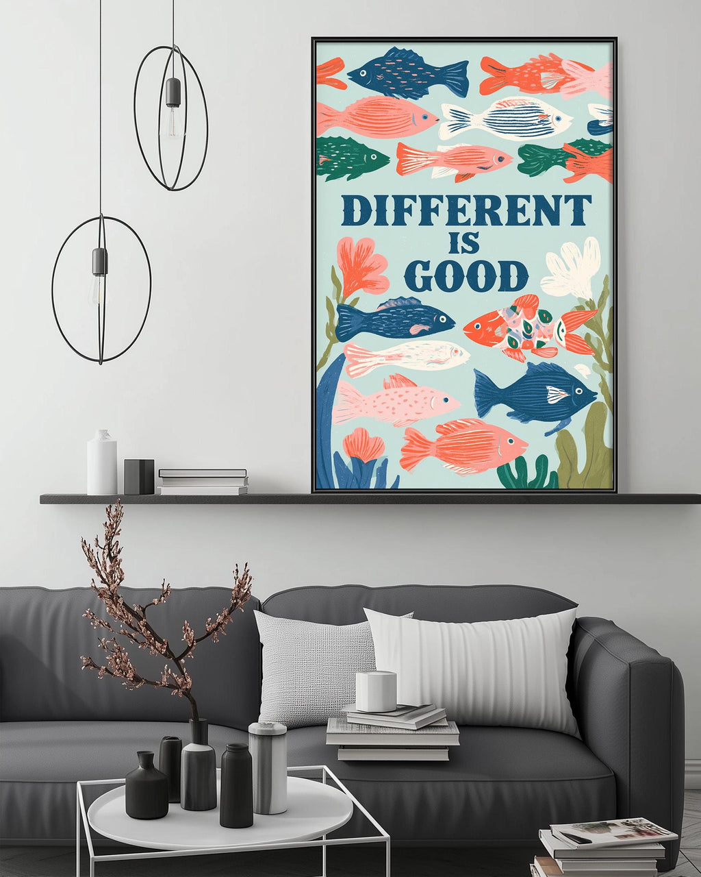 a living room with a gray couch, a coffee table, and a framed poster of colorful fish above it. The poster has the text "DIFFERENT IS GOOD" written on it.