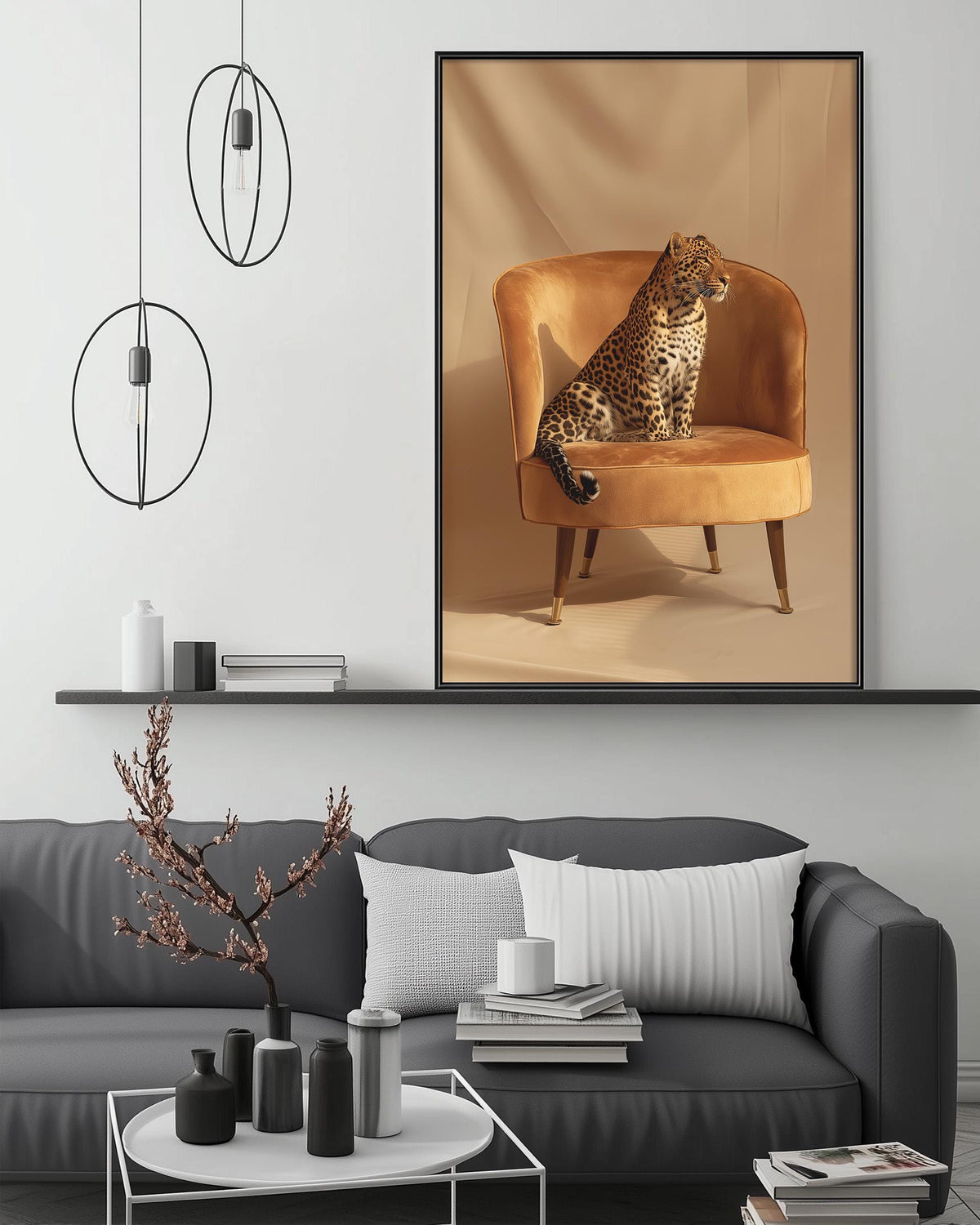 a large framed picture of a leopard sitting on an orange armchair, which is displayed on a wall above a gray couch in a living room setting.