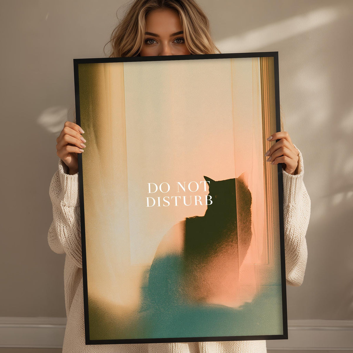 A woman holding a framed poster with a cat silhouette and the text "DO NOT DISTURB" on it.