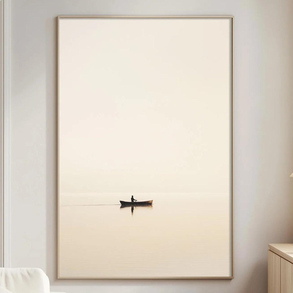 a serene living room with a large white sofa, a wooden side table, and a framed picture of a boat on a calm body of water.