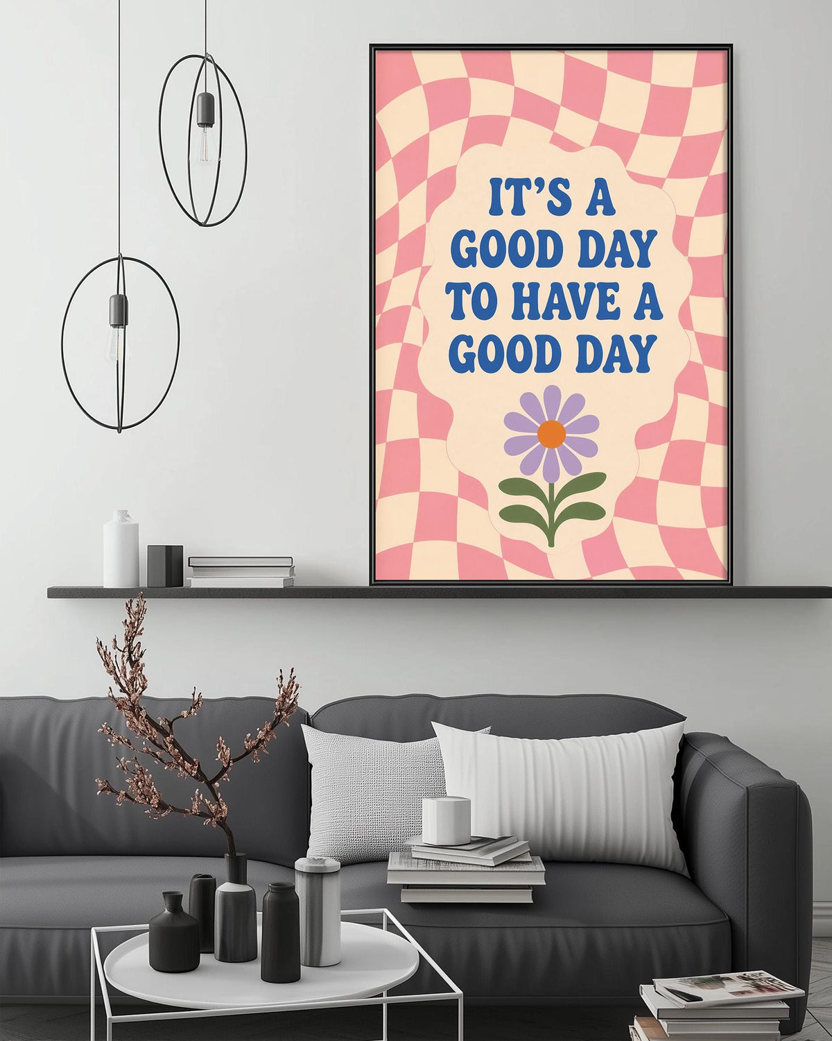 a living room with a gray couch, a coffee table, and a framed poster with a flower and the text "It's a good day to have a good day" on it.